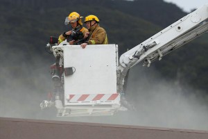 Firemen investigate the roof of the Harvey Norman building.